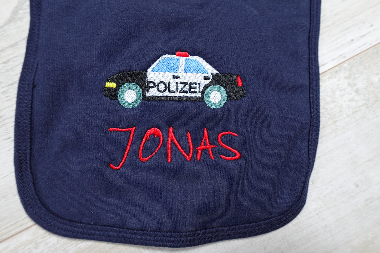 Lätzchen mit einem von uns gestickten Polizeiauto und Namen des Kindes