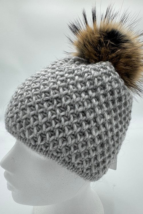 Schwarze Strickmütze IDA mit Bommel aus finnischem Waschbärfell.